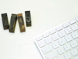 Eine Computertastatur und die Druckbuchstaben: T, Y, P und 9.