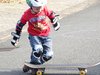Ein Junge mit Schützern und seinem Skateboard.