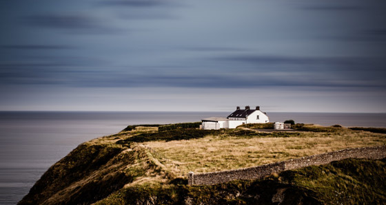 Bild von einem weißen Haus an der idylischen Küste Irlands.